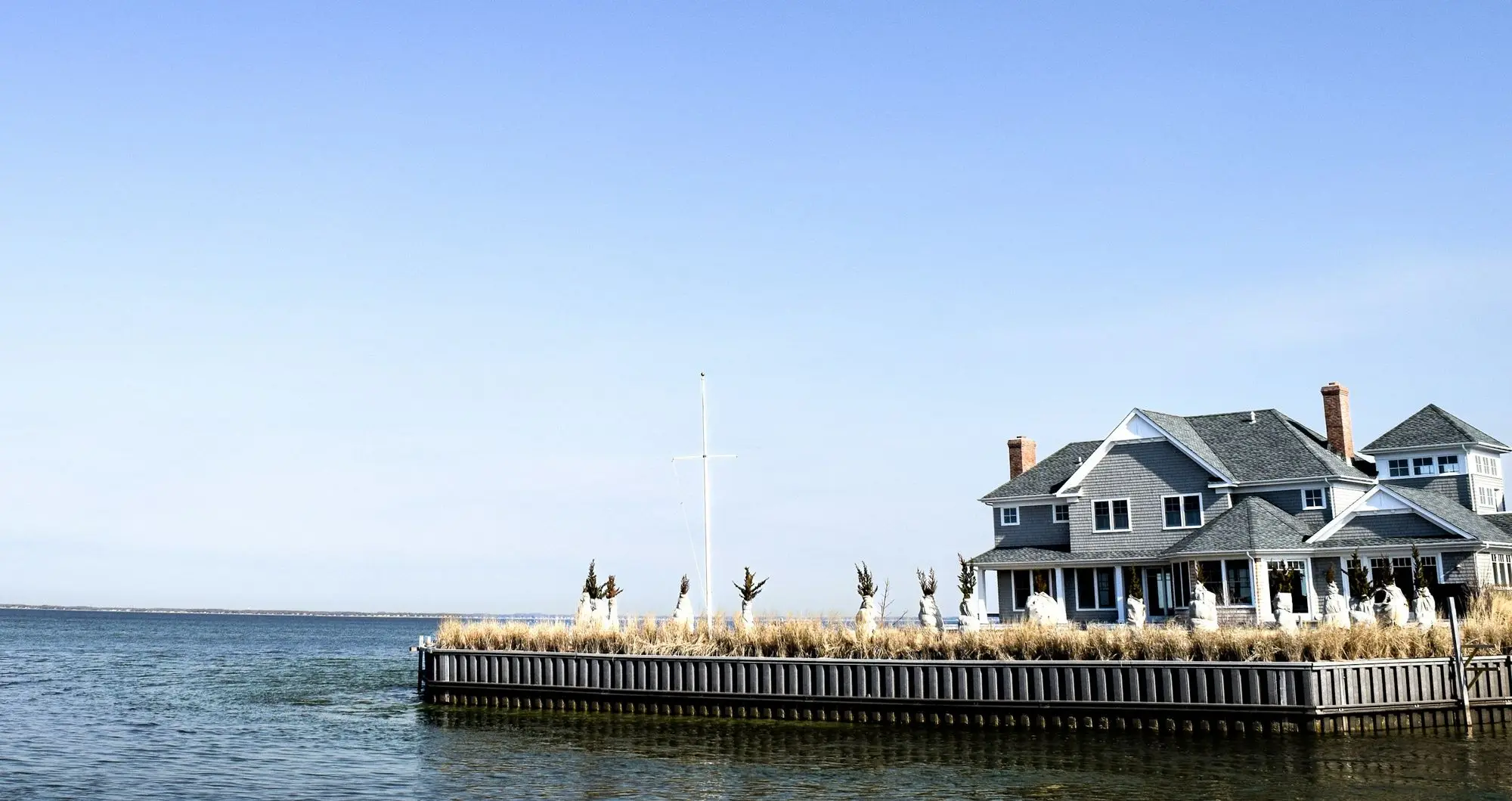 A house behind a bulkhead on open water