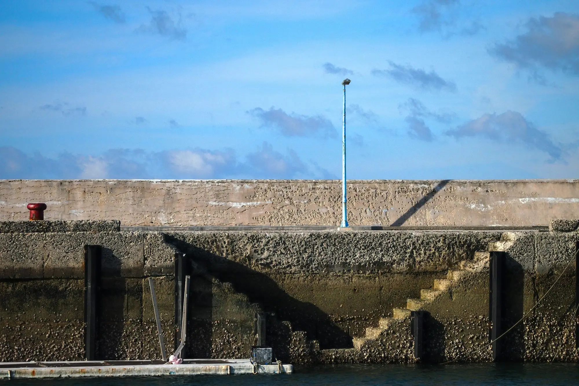A concrete seawall with a ladder down to the water